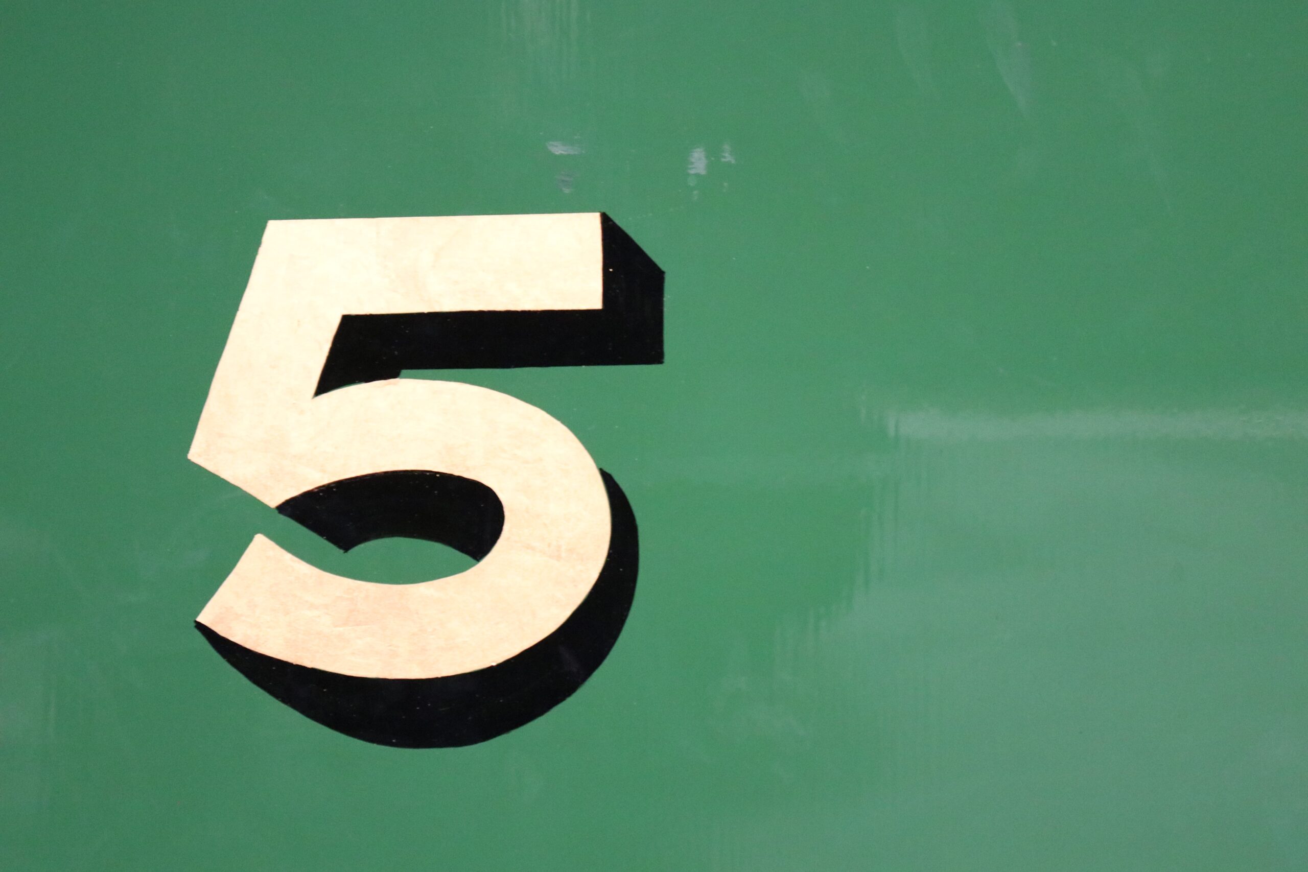 Number 5 painted on green surface