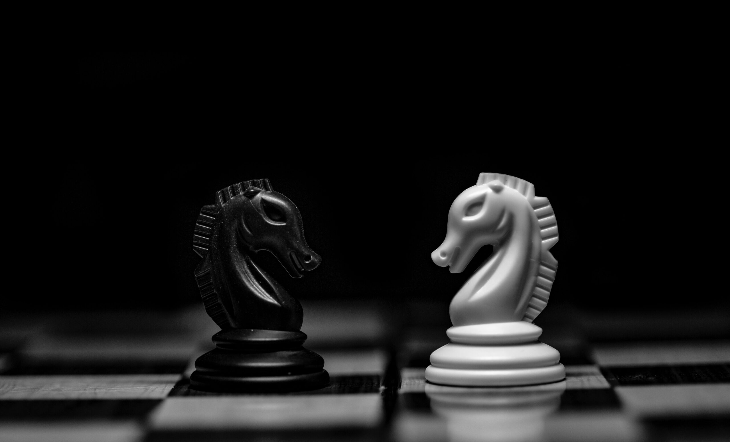 A black and white image of two chess pieces facing each other.